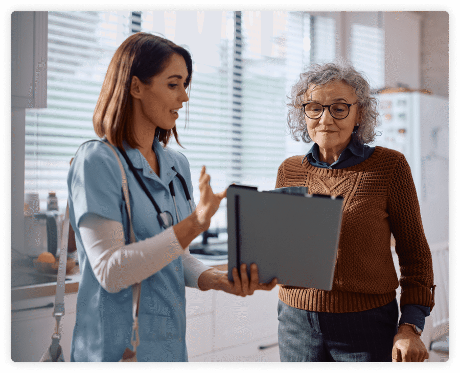 Nurse explaining medical chart to elderly woman